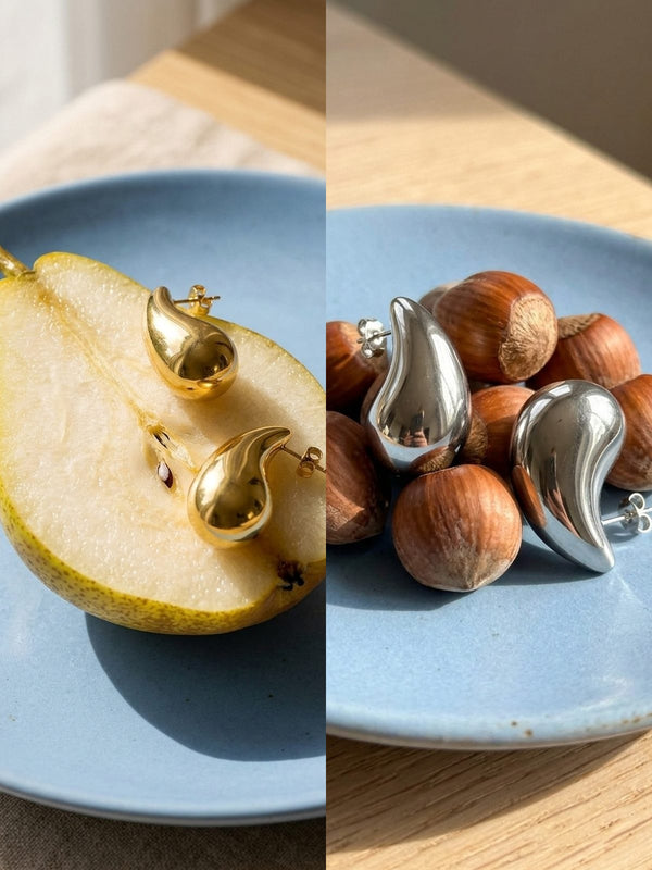 Lundholm Hazel oorbellen in goud op een peer en in zilver tussen hazelnoten