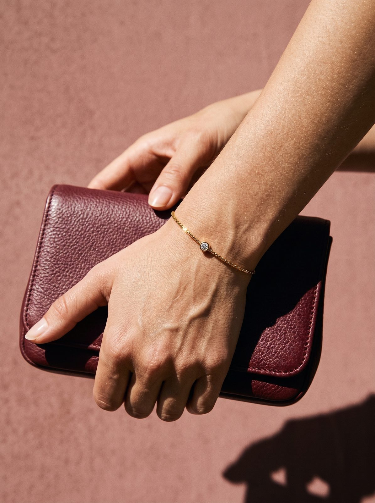 Lundholm Anah armband om een pols met een bordeauxrood avondtasje