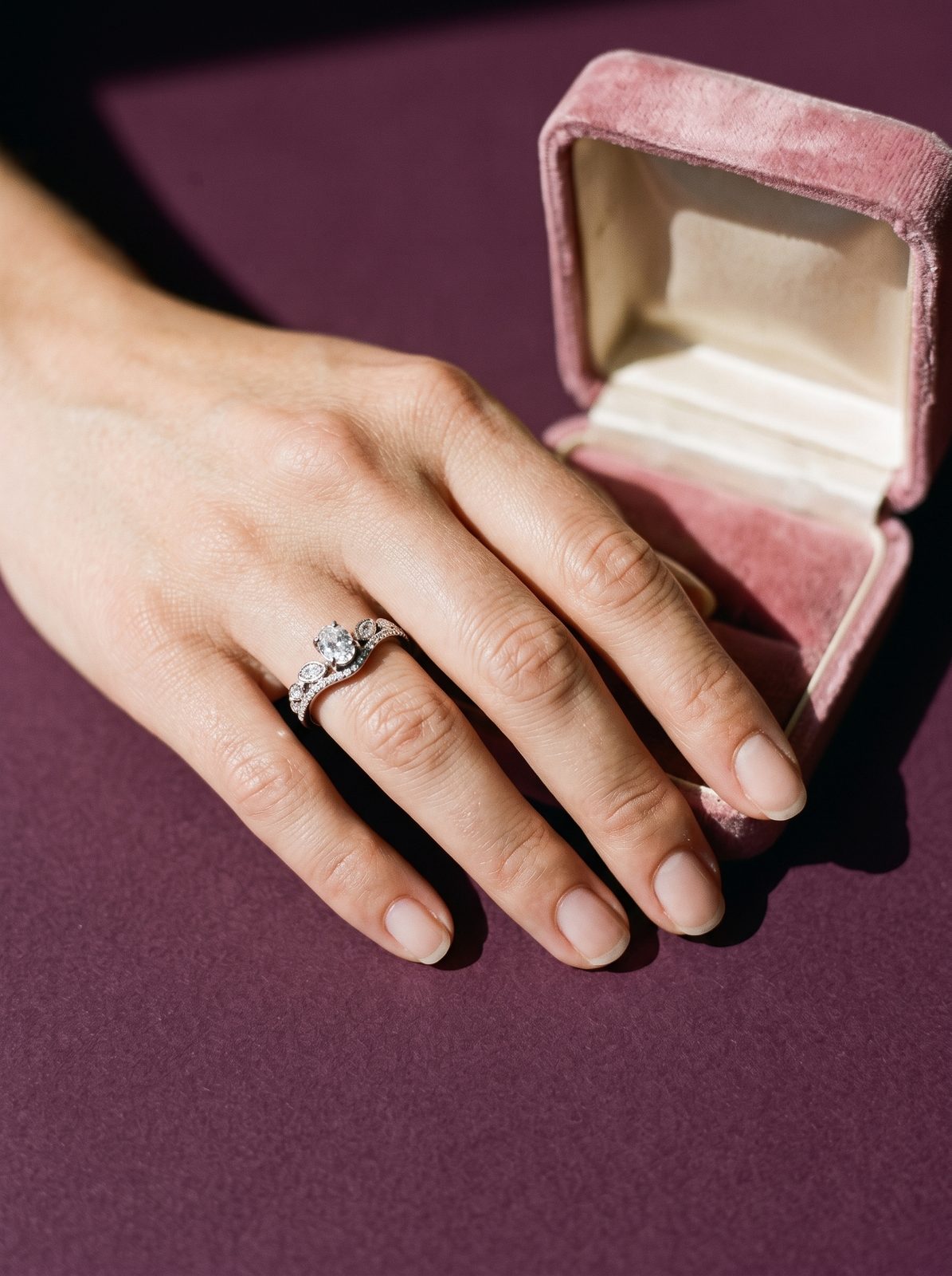 Lundholm Aurora ring aan een hand naast een fluwelen juwelendoosje