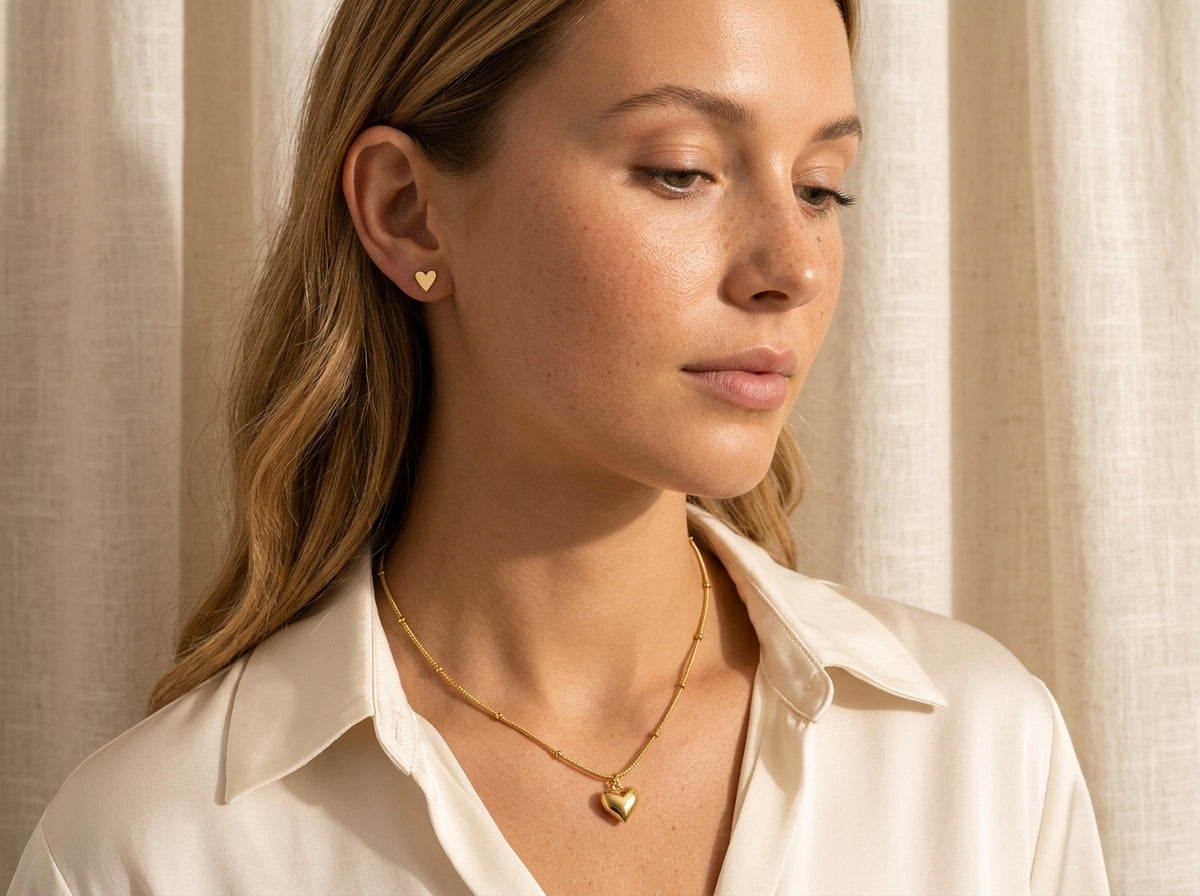 Vrouw draagt de kleine Lundholm Femme hartjes oorknopjes en de Lovez ketting met hartje