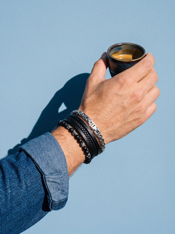 Lundholm herenarmbanden gestapeld om een pols met een espressokopje