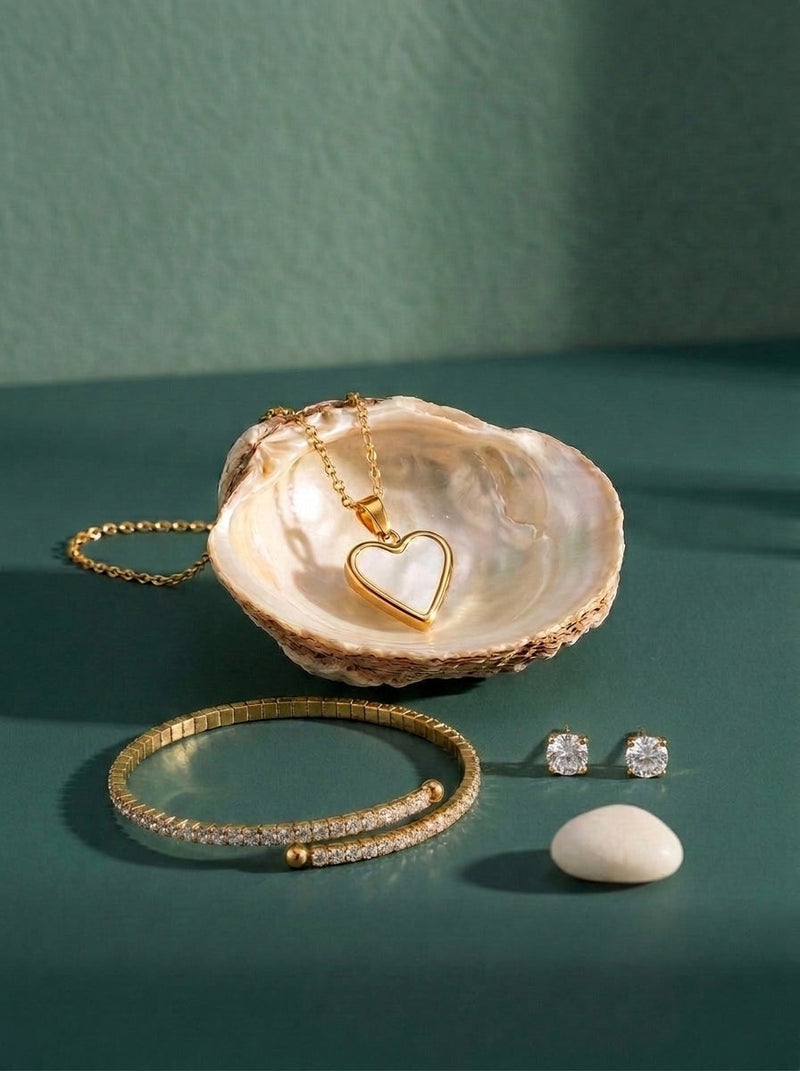 Lundholm look Fonkel en hart in goudkleurig: Yael tennisarmband, Dory hartjesketting met parelmoer in een schelp en Nikki zirkonia oorknopjes tegen zeegroen