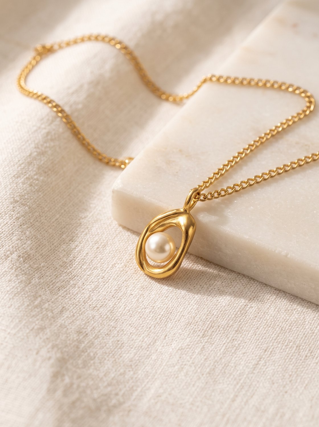 Lundholm Hilma ketting dames goudkleurig met imitatieparel hanger op marmer