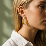 Model draagt de Lundholm Iris oorbellen goudkleurig