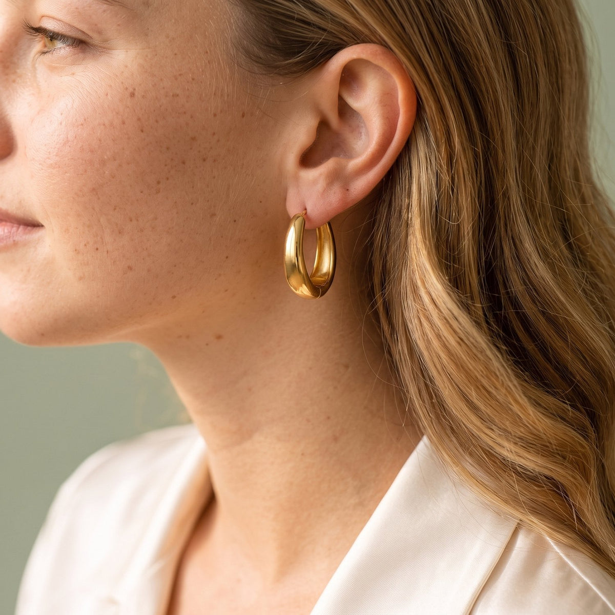 Model draagt de Lundholm Lea oorringen goudkleurig, close-up