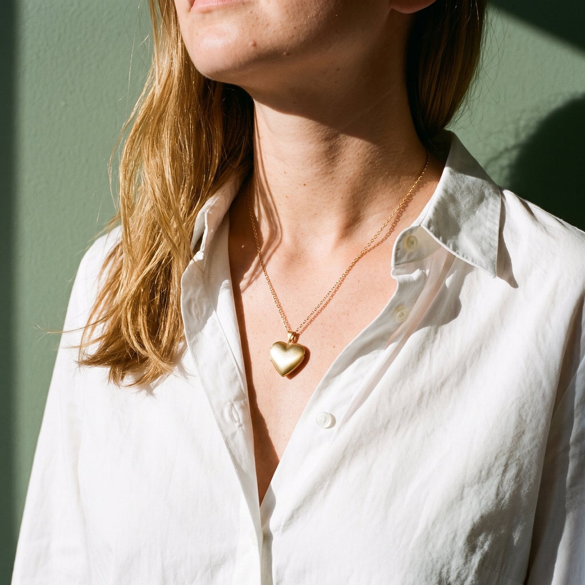 Vrouw draagt de Lundholm Isolde hart medaillon ketting goudkleurig