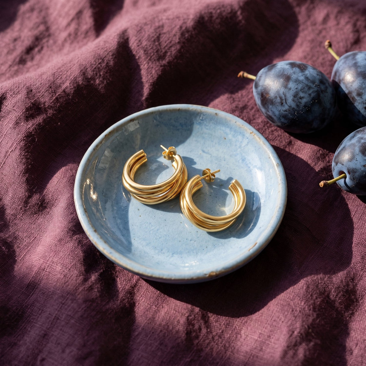 Lundholm Thea goudkleurige hoops op een blauw schaaltje