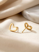 Lundholm Alma oorknopjes dames goudkleurig hartje op satijn lifestyle - premium stainless steel goud verguld - kleine hartjes 0.9 cm - Alma Serie - Scandinavisch design sieraad cadeau voor vrouw moederdag