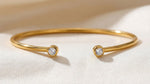 Lundholm Fem Serie open bangle cuff armband dames goudkleurig met zirkonia steentjes close-up macro op cream stof - waterproof gold plated PVD 2.5 micron premium stainless steel sieraden cadeau vrouw moederdag verjaardag Scandinavisch Design