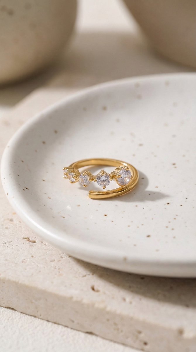 Lundholm Isabeau Serie minimalistische ring dames goudkleurig verguld met zirkonia stenen verstelbaar one size op crème keramische schaal lifestyle - waterproof gold plated PVD premium stainless steel sieraden cadeau vrouw moederdag verjaardag Scandinavisch Design