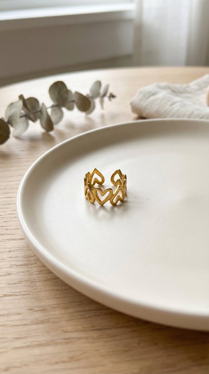 Lundholm Kara Serie hartjes liefde ring dames goudkleurig verguld verstelbaar one size op crème keramische schaal met droogbloemen lifestyle - waterproof gold plated PVD premium stainless steel sieraden cadeau vrouw moederdag verjaardag Scandinavisch Design