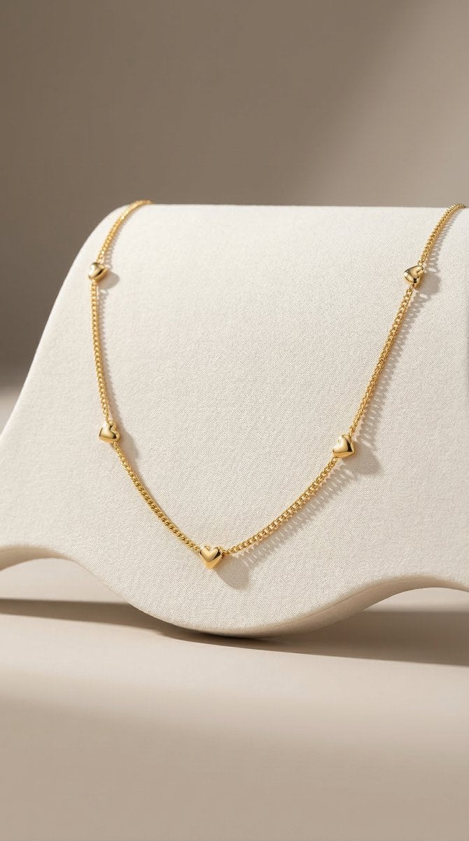Lundholm minimalistische ketting dames goudkleurig verguld met mini hartjes 40cm op crème stof display productfoto - waterproof gold plated PVD premium stainless steel sieraden cadeau vrouw moederdag verjaardag Scandinavisch Design