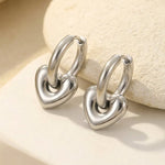 Lundholm Lovea Serie oorbellen dames zilverkleurig met chunky hartjes hangers symbool van liefde op crème steen achtergrond - waterproof premium stainless steel sieraden cadeau vrouw moederdag verjaardag Scandinavisch Design