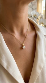 Lundholm luxe ketting dames goudkleurig met ronde zirkonia steen hanger gedragen door model in witte blouse lifestyle - hypoallergeen waterproof gold plated PVD premium stainless steel sieraden cadeau vrouw moederdag verjaardag Scandinavisch Design