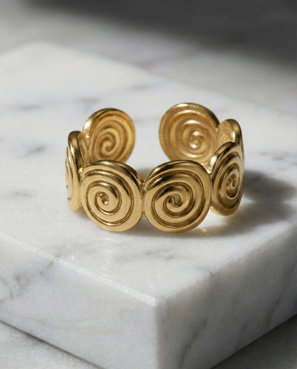 Lundholm Merel goudkleurige verstelbare ring voor dames met aesthetic spiraal swirl ontwerp, gefotografeerd op witte marmeren ondergrond voor stijlvolle productshot. Premium stainless steel met PVD gold plating van 2.5 micron, waterproof en hypoallergeen. Een unieke cadeau voor vrouw, moeder of vriendin op Moederdag of verjaardag in Scandinavisch design.