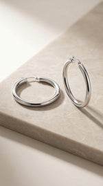 Lundholm Eefje hoops zilver op travertijn steen — productfoto styling premium