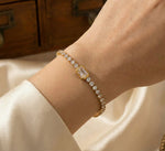 Lundholm My Jasmijn Serie luxe armband voor dames in goudkleurig met zirkonia stenen in tennis-stijl gedragen aan pols van model in lifestyle setting, gemaakt van premium stainless steel met PVD coating van 2.5 micron, waterproof en hypoallergeen, perfect cadeau voor vrouw, moederdag of verjaardag in Scandinavisch design.