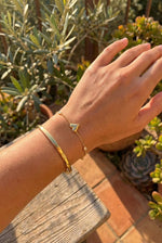 Lundholm My Jutta goudkleurige armband voor dames met romantische hartjes en zirkonia steentjes, gedragen door vrouw outdoor met olijfboom en succulenten voor warme mediterrane lookbook lifestyle shoot. Premium stainless steel met PVD gold plating van 2.5 micron, waterproof en hypoallergeen. Een romantisch cadeau voor vrouw, moeder of vriendin op Moederdag of verjaardag in Scandinavisch design.