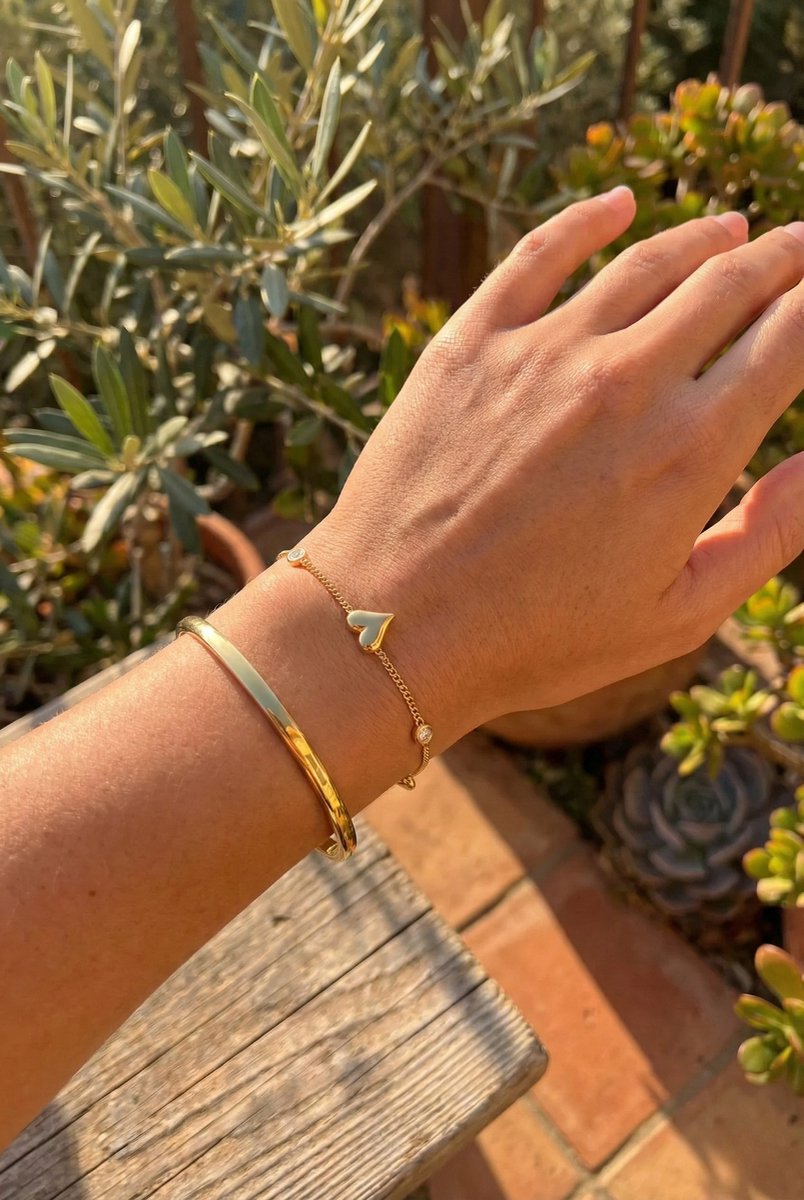 Lundholm My Jutta goudkleurige armband voor dames met romantische hartjes en zirkonia steentjes, gedragen door vrouw outdoor met olijfboom en succulenten voor warme mediterrane lookbook lifestyle shoot. Premium stainless steel met PVD gold plating van 2.5 micron, waterproof en hypoallergeen. Een romantisch cadeau voor vrouw, moeder of vriendin op Moederdag of verjaardag in Scandinavisch design.