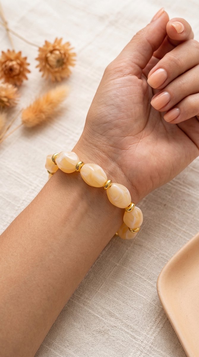 Lundholm My Mace Serie kralen armband dames beige met grote kralen gedragen door model op pols met droogbloemen lifestyle - waterproof gold plated PVD premium stainless steel sieraden cadeau vrouw moederdag verjaardag Scandinavisch Design