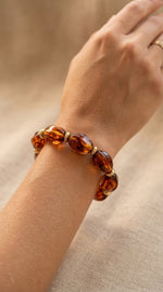 Lundholm My Mace Serie kralen armband dames donker bruin tortoise schildpad design gedragen door model op pols lifestyle - waterproof gold plated PVD premium stainless steel sieraden cadeau vrouw moederdag verjaardag Scandinavisch Design
