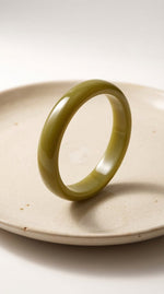 Lundholm My May Serie statement bangle armband dames olijfgroen acryl op crème keramische schaal productfoto - cadeau vrouw vriendin moederdag verjaardag Scandinavisch Design