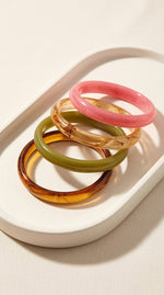 Lundholm My May Serie statement bangle armband dames in vier kleuren roze beige olijfgroen en tortoise bruin acryl samen op crème dienblad lifestyle - cadeau vrouw vriendin moederdag verjaardag Scandinavisch Design