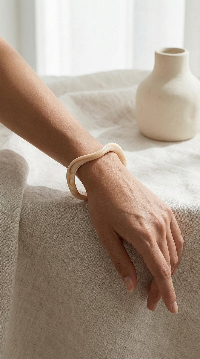 Lundholm My Nienke Serie moderne wave bangle armband dames beige hars resin gedragen door model op pols lifestyle linnen vaas - cadeau vrouw moederdag verjaardag Scandinavisch Design