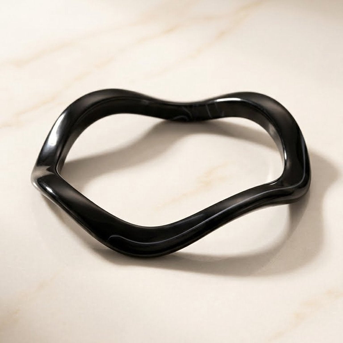 Lundholm My Nienke Serie moderne wave bangle armband dames zwart hars resin one size statement op crème marmer lifestyle - cadeau vrouw moederdag verjaardag Scandinavisch Design