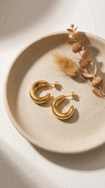 Lundholm My Sol Serie chunky hoop oorknopjes dames goudkleurig verguld op crème keramische schaal met herfst droogbloemen lifestyle - waterproof gold plated PVD premium stainless steel sieraden cadeau vrouw moederdag verjaardag Scandinavisch Design