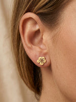 Lundholm Tropicana oorknopjes dames goudkleurig hibiscus bloem gedragen door model close-up - premium stainless steel - Tropicana Serie - Scandinavisch design botanisch sieraad cadeau voor vrouw moederdag