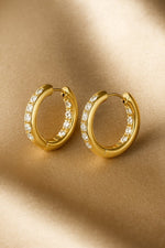Lundholm Oorringen Dames Goudkleurig met Witte Zirkonia - Premium Stainless Steel Gold Plated - Luxe Hoops (2.45 cm) - Elegant & Tijdloos - Luxe Geschenkverpakking
Ontdek verfijnde luxe met de Lundholm oorringen met witte zirkonia. Deze elegante goudkleurige hoops zijn gemaakt van hoogwaardig premium stainless steel met een duurzame vergulde afwerking en afgewerkt met fonkelende witte zirkonia steentjes die een schitterende, diamantachtige glans geven. Een perfecte combinatie van tijdloze klasse en moderne 