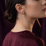 Lundholm Brielle oorringen gedragen bij een bordeaux zijden blouse