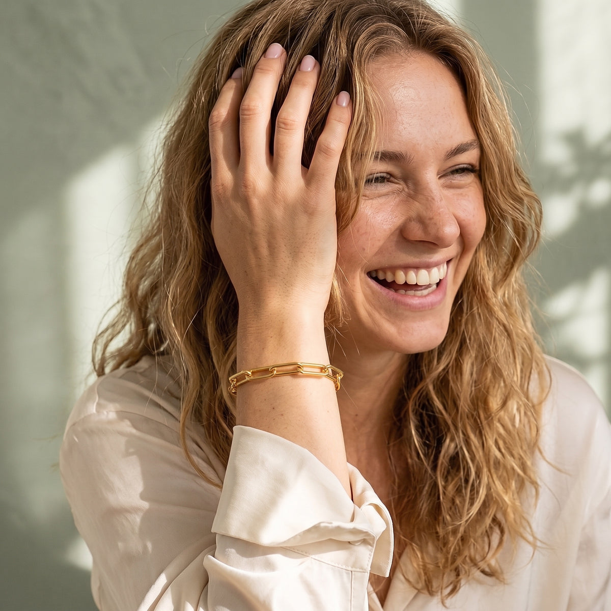 Lundholm Elaine armband goud om de pols van een lachende vrouw