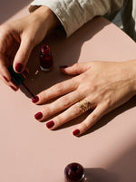 Lundholm Alexia verstelbare ring met zirkonia goudkleurig gedragen, hand met bordeauxrode nagellak
