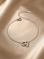 Lundholm Alice armband zilverkleurig met twee verstrengelde hartjes op gouden zijde, schakelarmband sieraad cadeau