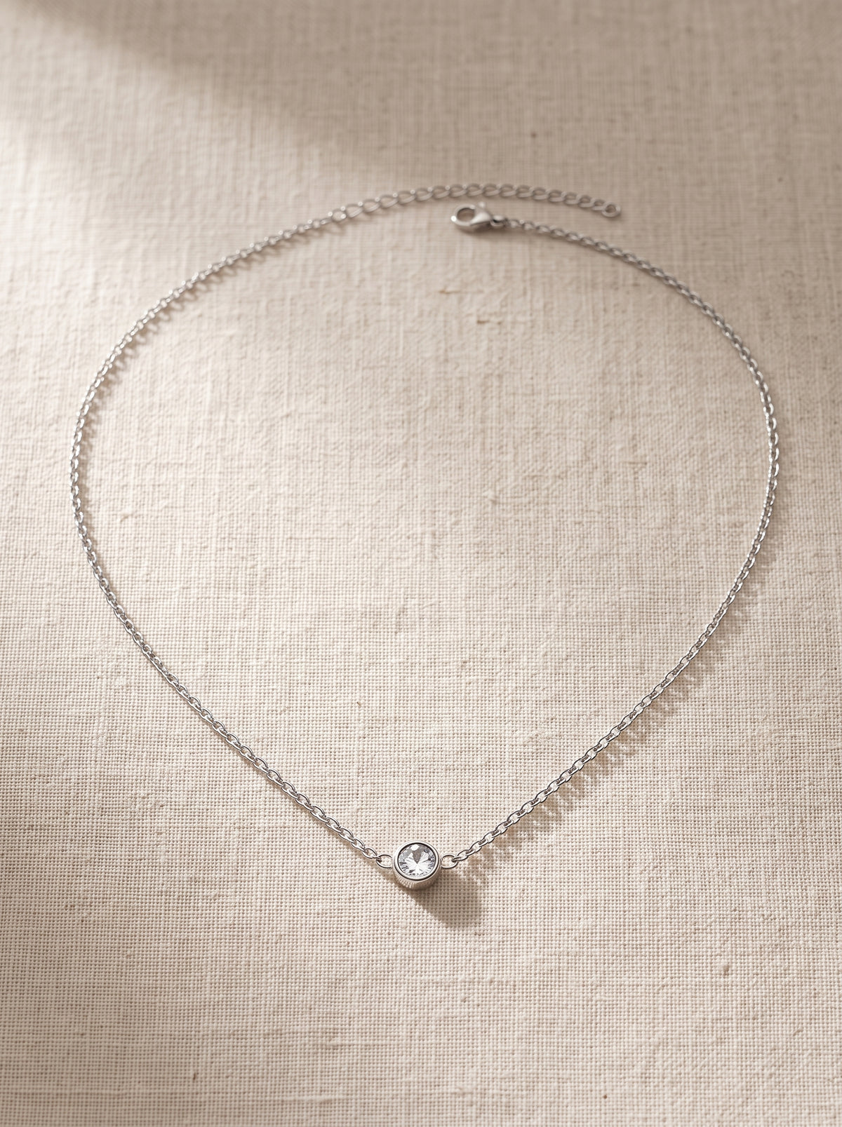 Lundholm Anah ketting zilverkleurig met kleine zirkonia hanger op linnen, fijne schakelketting van premium stainless steel