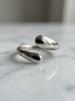 Close-up van de glanzende druppels van de Lundholm Dagny ring op marmer – Scandinavisch design