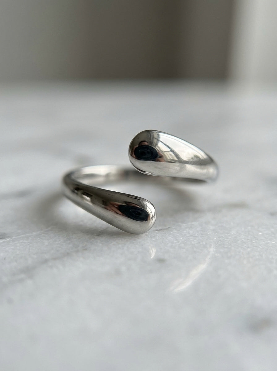 Close-up van de glanzende druppels van de Lundholm Dagny ring op marmer – Scandinavisch design