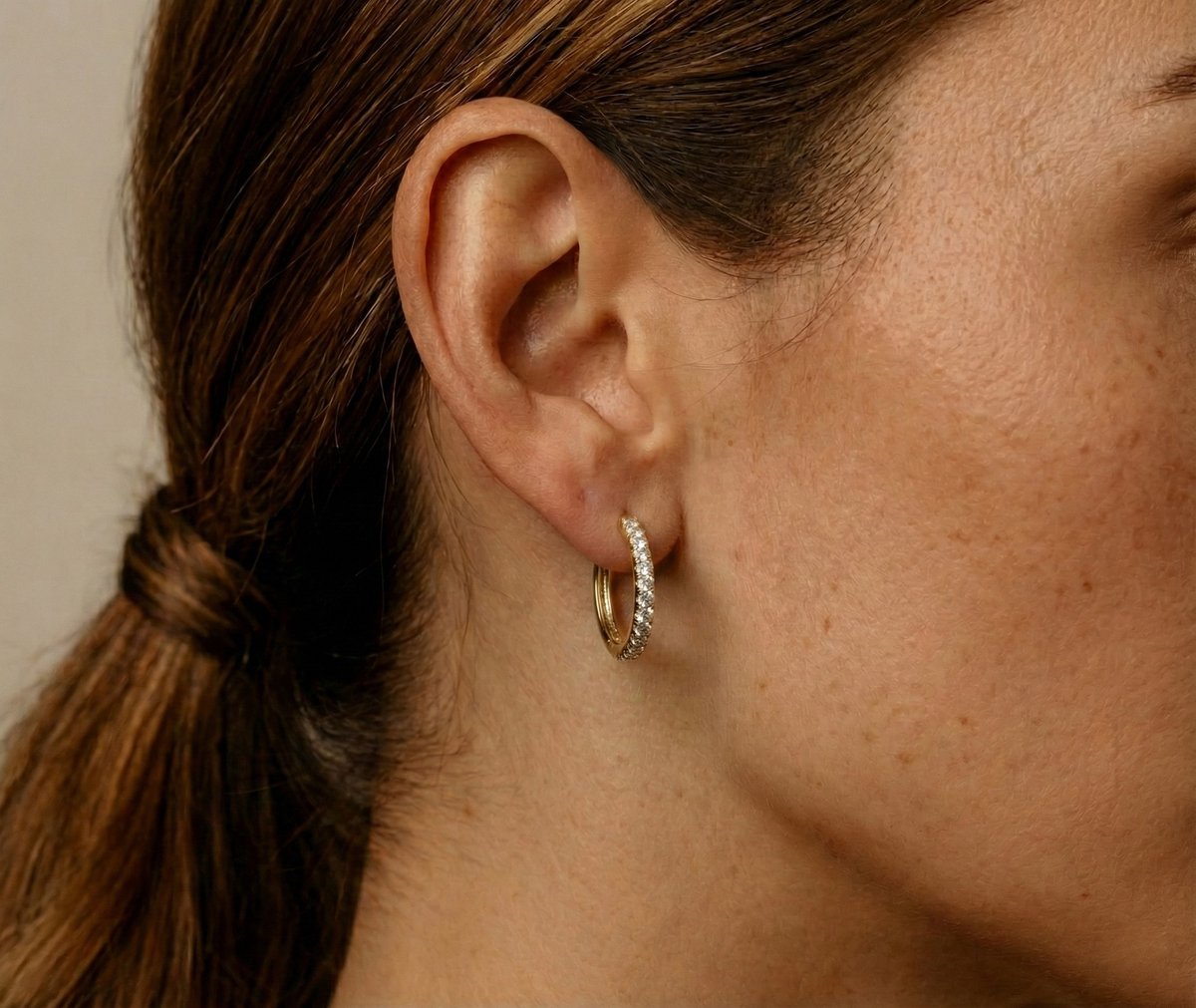 Lundholm My Delia creolen oorringen met zirkonia steentjes in goudkleurig 18mm, gedragen aan vrouwenoor