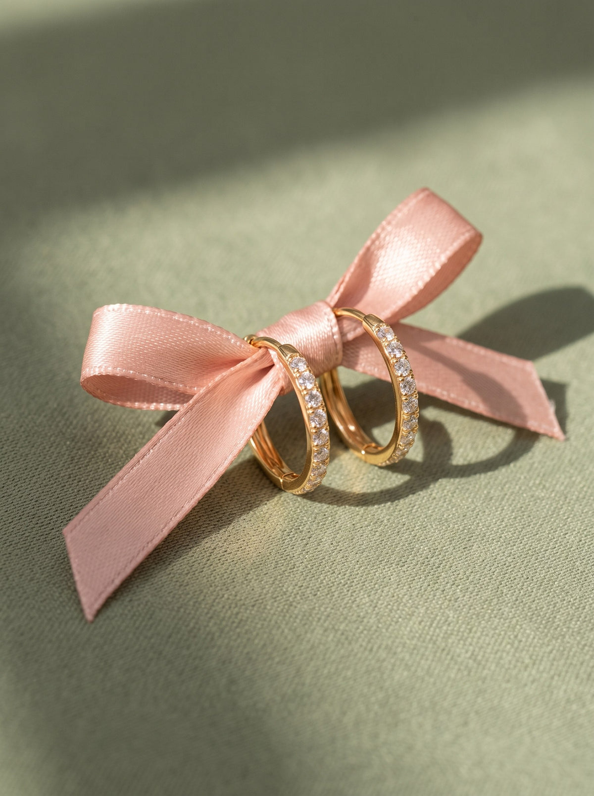Lundholm Delia kleine oorringen met zirkonia goudkleurig aan een roze satijnen strik