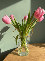 Lundholm Eefje creolen goudkleurig aan roze tulpen in een glazen vaasje