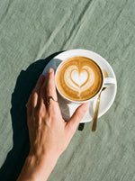 Lundholm Elia minimalistische ring goudkleurig gedragen, hand om een cappuccino