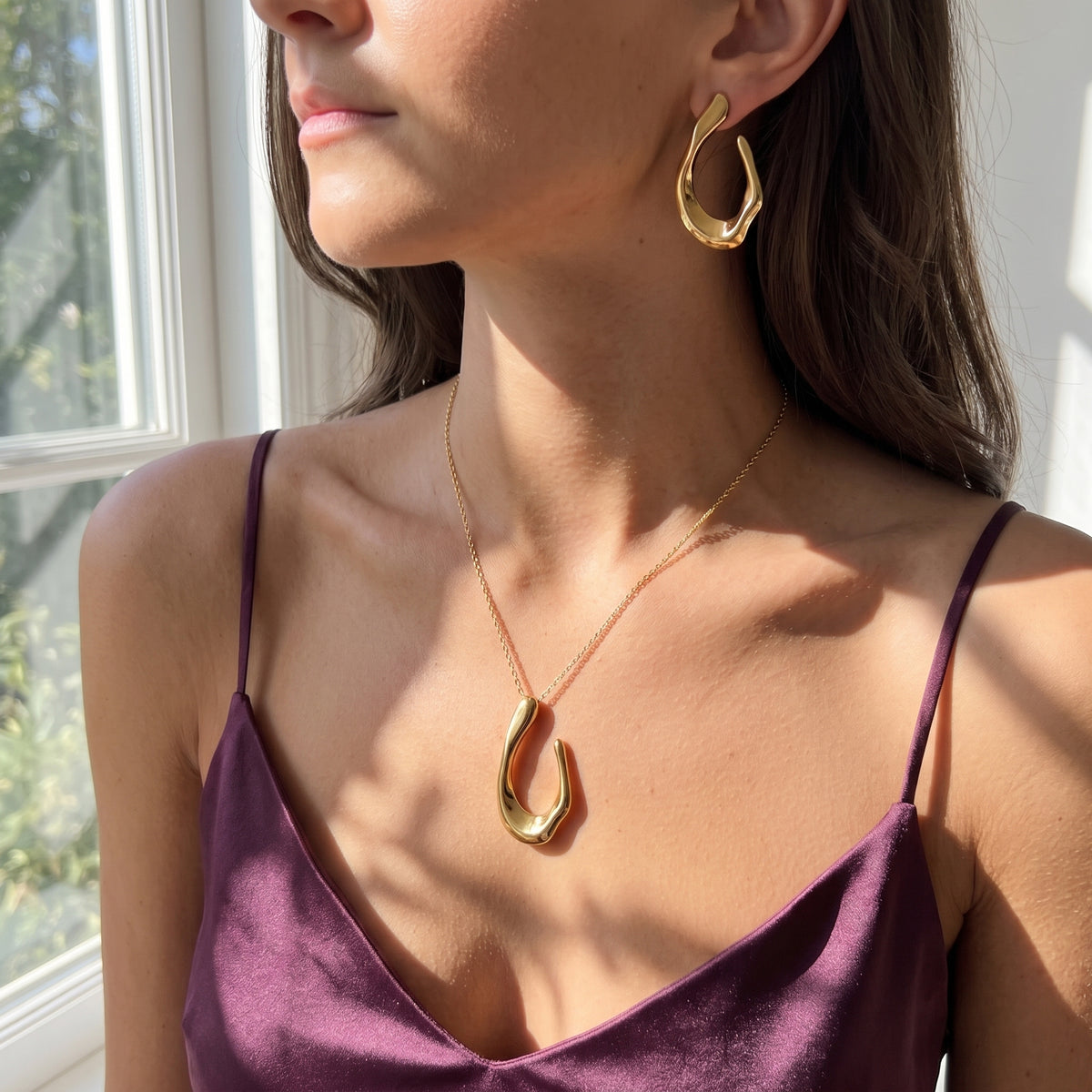 Lundholm Iris ketting en oorbellen gedragen bij plum satijnen top