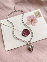 Lundholm Kerstin paperclip ketting met bol hartje zilverkleurig op een liefdesbrief met lakzegel