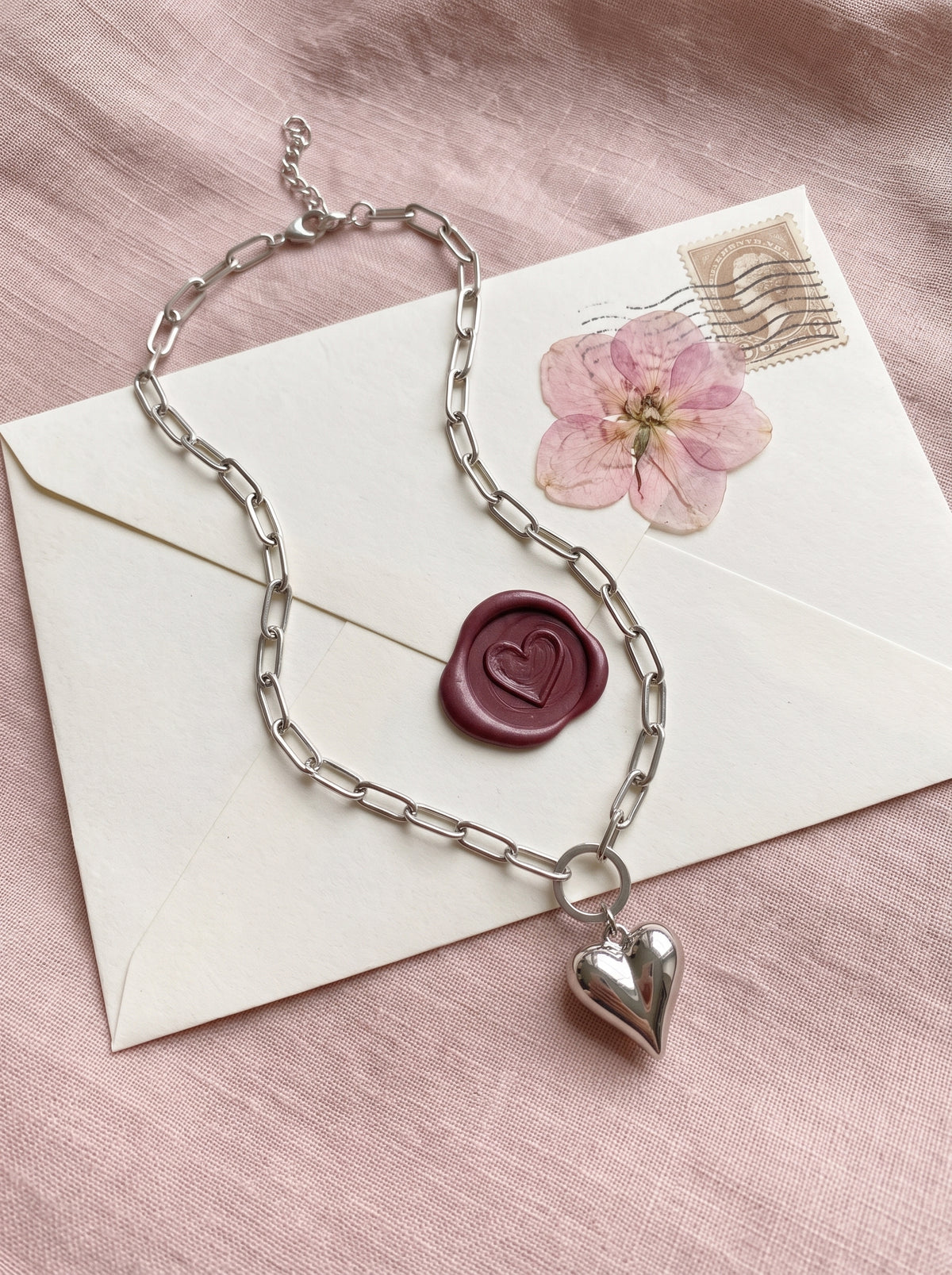 Lundholm Kerstin paperclip ketting met bol hartje zilverkleurig op een liefdesbrief met lakzegel