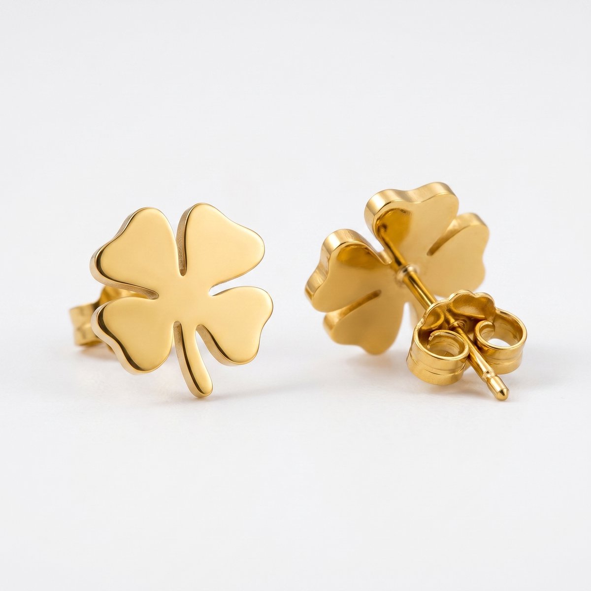 Lundholm Klara oorknopjes goud klavertje vier studs flat-lay close-up — premium stainless steel PVD gold plated damesoorbellen