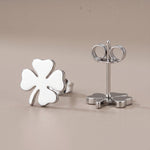 Lundholm Klara oorknopjes zilver klavertje vier studs flat-lay close-up — premium stainless steel damesoorbellen