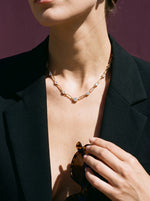 Vrouw in zwarte blazer draagt de Lundholm Layla paperclip ketting met zirkonia goudkleurig