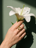 Lundholm Lily verstelbare bloemenring met zirkonia goudkleurig gedragen, hand met een witte lelie